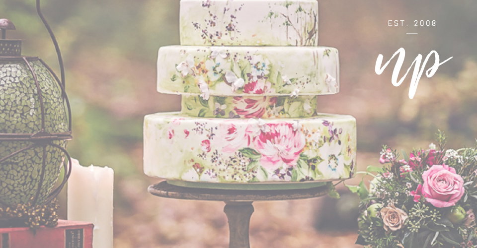 A photograph of a beautiful hand painted wedding cake, created by Nevie-Pie Cakes.